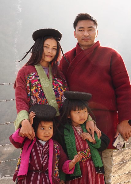 Familie met bijzondere hoedjes in Sakteng, Bhutan