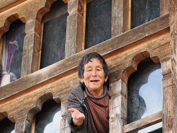 Vrouw wenkt ons voor de lunch in de Phobjikha vallei, Bhutan
