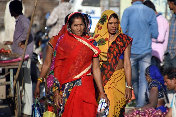 Kleurige vrouwen op een groentemarkt in Madhya Pradesh (India)