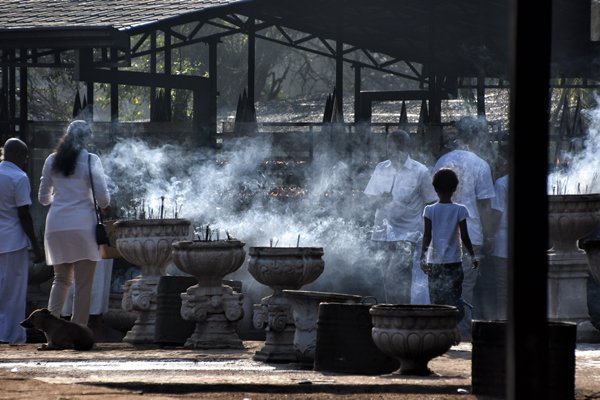 Pelgrims in wit branden kaarsjes bij de Bodhiboom in Anuradhapura (Sri Lanka)