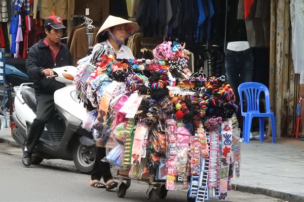 Een straatverkoopster in Hanoi met allerlei spullen voor haarversiering
