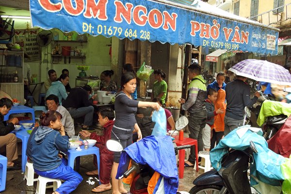 Tijdens het eten in Hanoi laat je je poncho op de brommer hangen