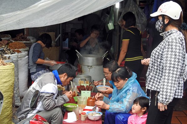 Deze eters in Hanoi houden hun regenkleding aan