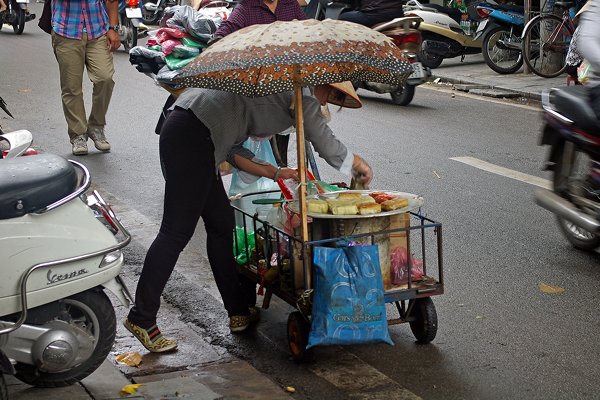 Verkoop van onduidelijk voedsel op een wat smoezelig wagentje, Hanoi