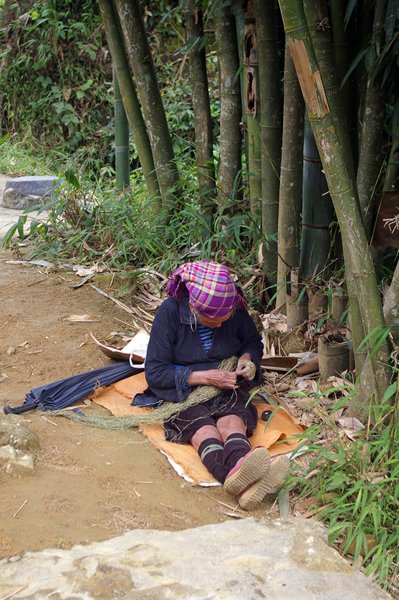Vrouw bij Sin Chai (Vietnam) druk bezig met een soort vezels
