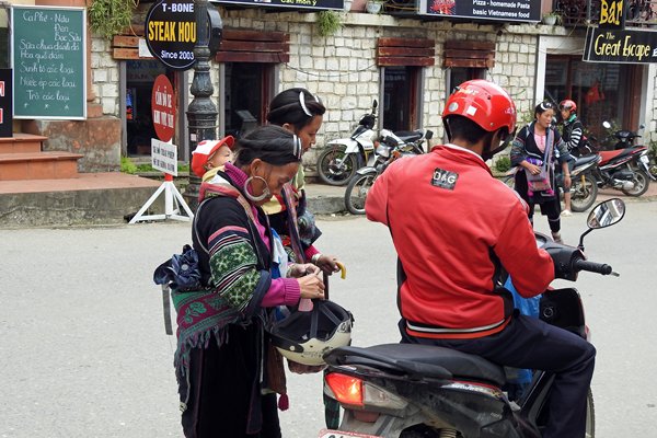 Ook bij klederdracht (Sa Pa, Vietnam) moet een bromfietshelm