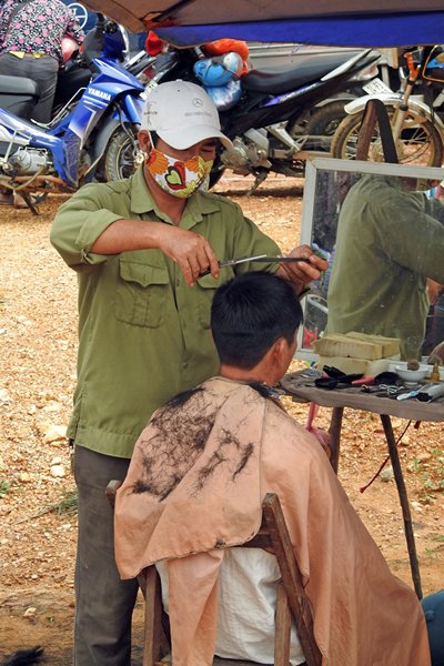 Kapper op de markt van Coc Ly, Vietnam
