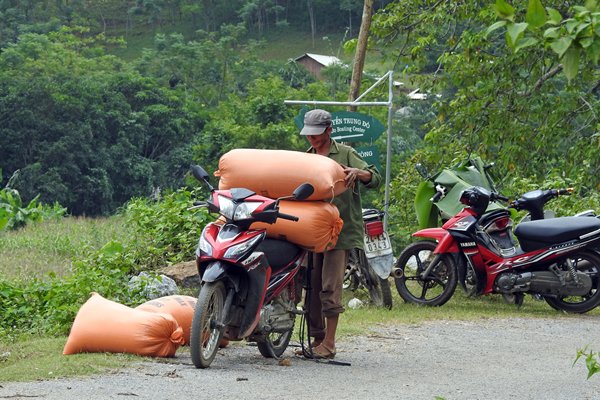 Brommer die beladen met goederen terugkomt van de markt van Coc Ly, Vietnam