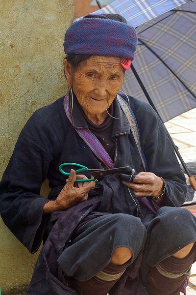 Blauwe M'Hong vrouw bezig met schaar en handwerk
