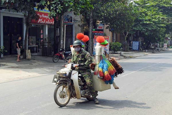 Bezemverkoper op zijn brommertje in Mai Chau, Vietnam