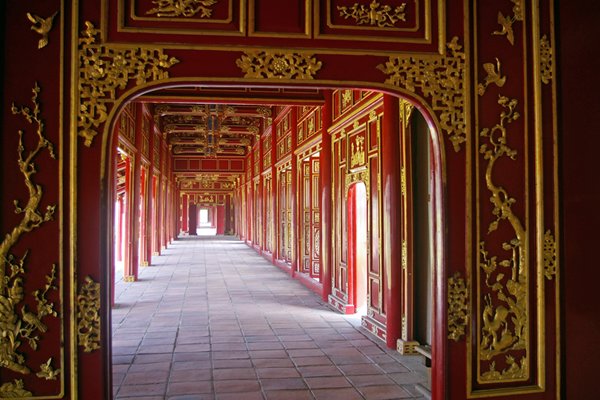 Galerij met rode houten palen en mooi plafond in de citale van Hué (Vietnam)