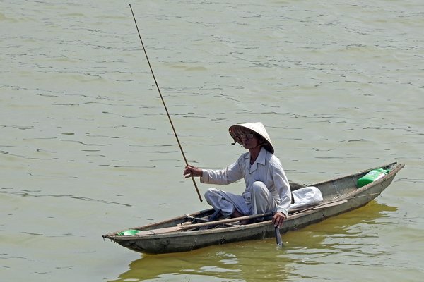 Visser op de Parfum rivier in Hué (Vietnam)