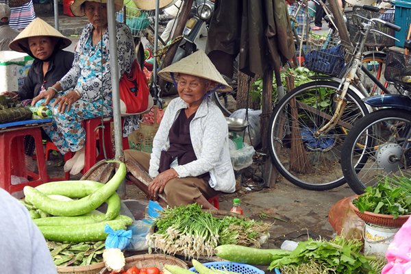 Oudere groenteverkoopster op de markt van Hoi An, Vietnam
