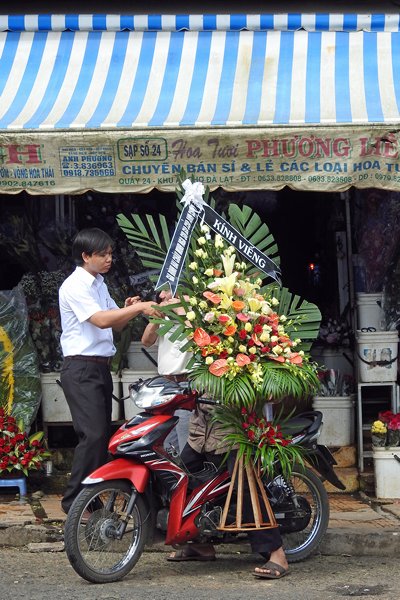 Zeer groot bloemstuk wordt vervoerd op brommer (Dalat, Vietnam)