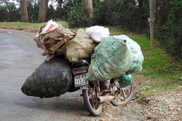 Zwaar beladen scooter in de villawijk, Vietnam