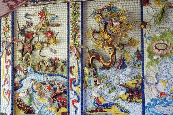 Muurdecoratie, een mozaïek van gekleurd glas en keramiek in Trai Mat, Vietnam