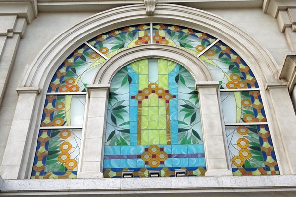 Fraai versierd raam in een soort art deco gebouw in Saigon
