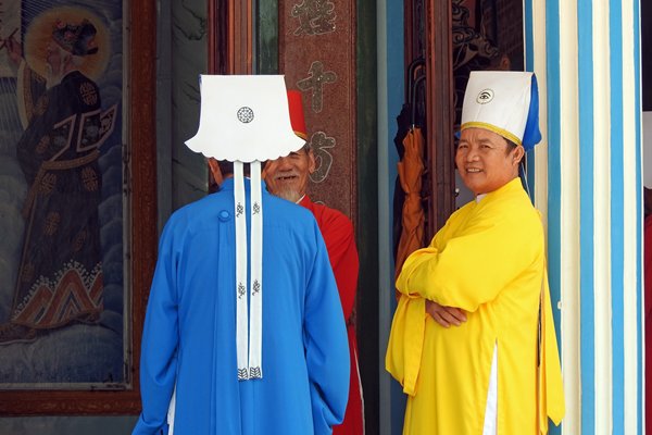 Priesters in geel, rood en blauw bij de Cao Dai tempel