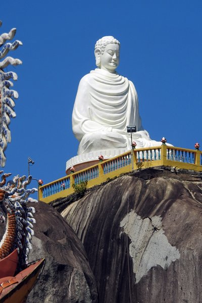 Een groot Boeddhabeeld bovenop de tempel bij de steengroep Da Ba Chong