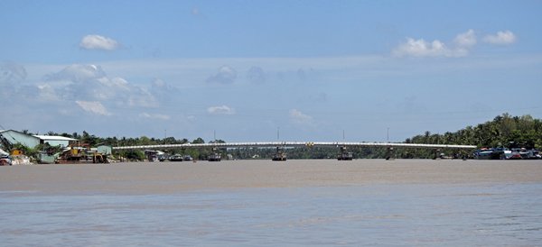 Een lange verkeersbrug over de brede Mekong rivier