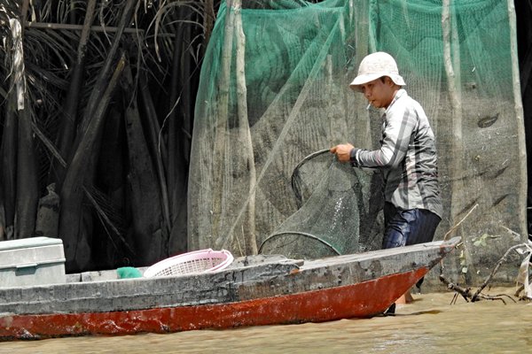 Een visser aan het werk in de Mekong delta