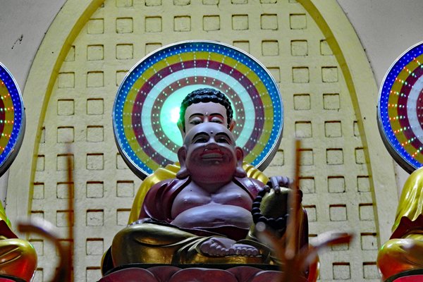 Boeddhabeeld met veel lichtjes erachter in de Chua Khanh Quang tempel in Can Tho, Vietnam