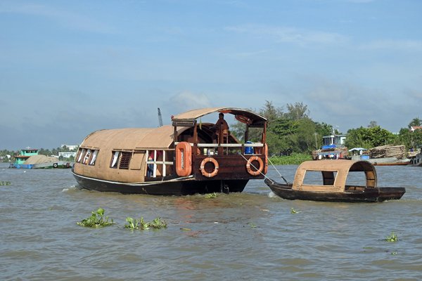 Boot met klein bootje erachter op de Mekong rivier bij Can Tho, Vietnam