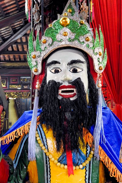 Indrukwekkende wachter met baard en blauwe mantel in de Binh Thuy tempel bij Can Tho, Vietnam