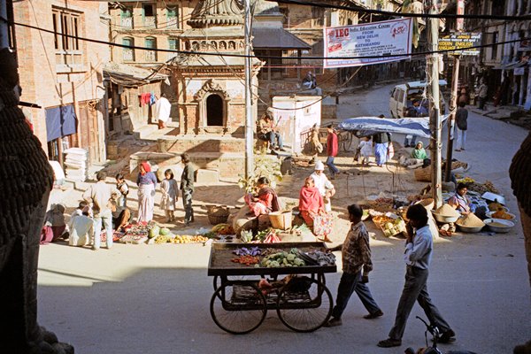 Diverse groenteverkopers, waaronder één met een hoge handkar, in Patan 1997